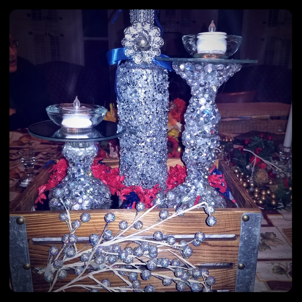 A set of candle holders and a bottle with a candle